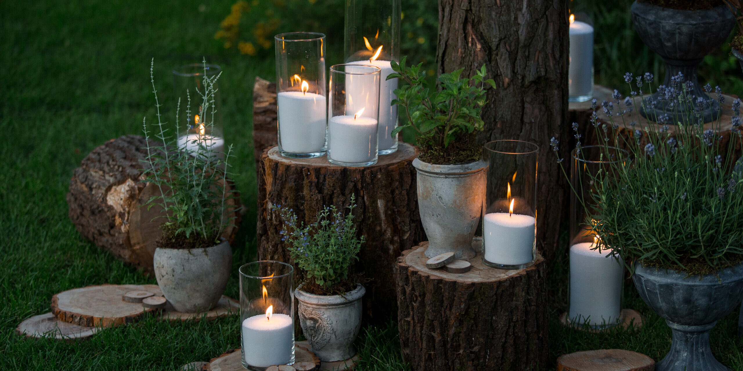 Tall vases with white candles stand on the blocks in the garden
