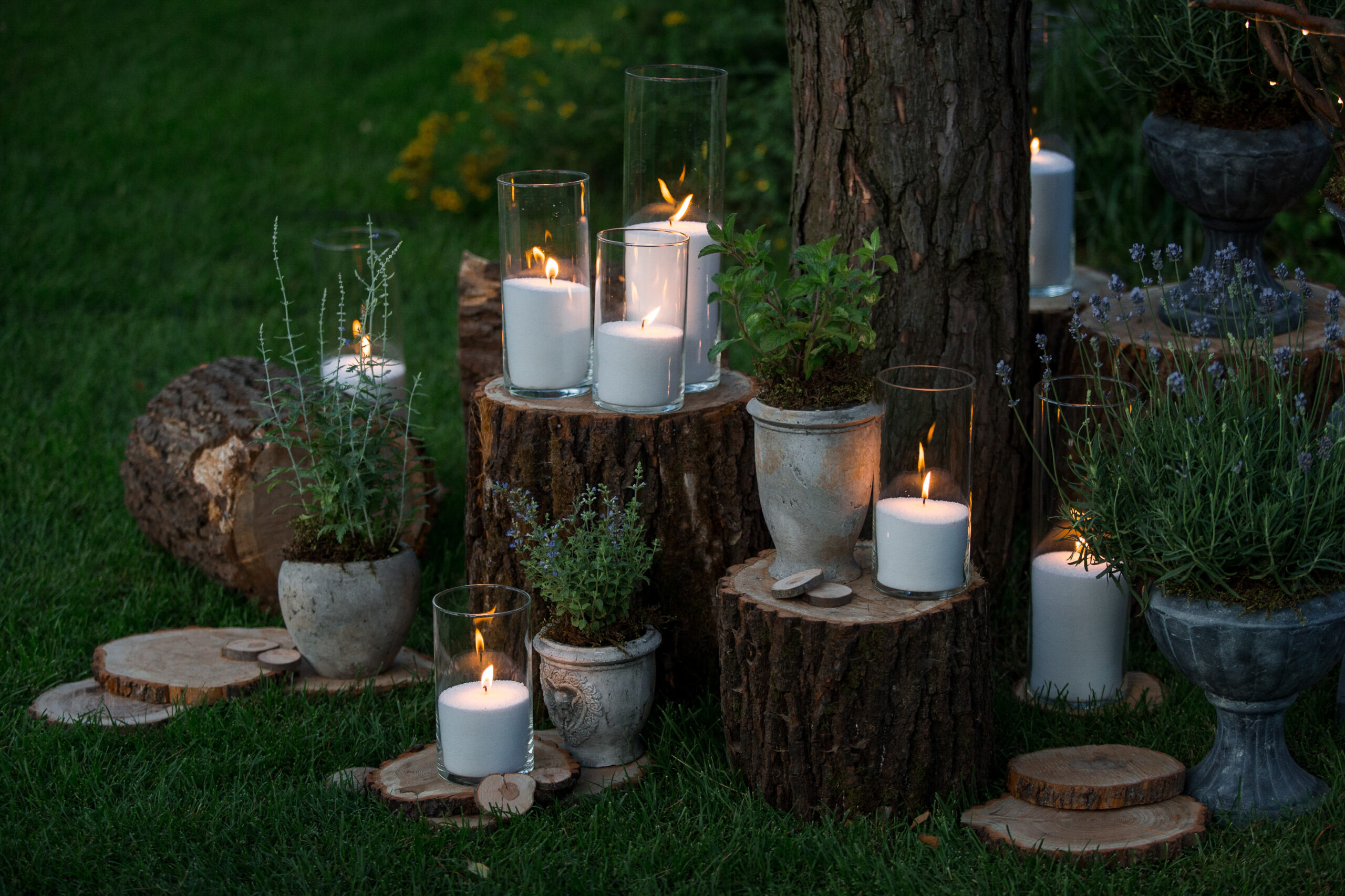 Tall vases with white candles stand on the blocks in the garden